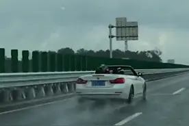 一辆敞篷车雨里奔驰，车里的人戴起了头盔，网友：不会打开车顶？图片