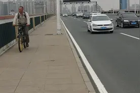 公路大桥上没有专用自行车道，一些市民在人行道上骑行，影响行人图片