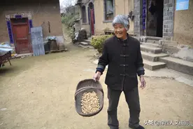 河南山里大娘过年贴紫色对联，陌生人路过帮剥花生，拽着不让走图片