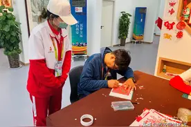 残运会上的志愿者“小秦宝”助聋哑人摄影师体验非遗项目图片