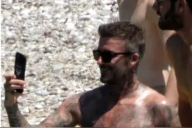 海边度假，贝克汉姆赤裸上身大秀身材，大儿子却穿着T恤戴着帽子图片