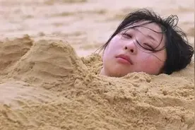 在海边玩的时候千万不要把自己埋进沙子图片
