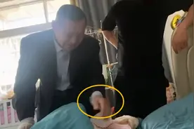 爷爷戴着手套看孙女，想碰宝宝的脸蛋儿却被宝爸拒绝：不能摸图片