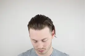 小伙子把头发往后梳，扎成发结后，时尚之余又个性！