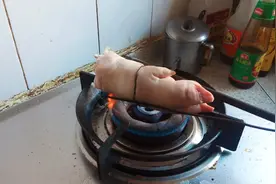 把猪蹄放到灶火上烤，去除猪毛味