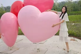 爱心雕塑旁，拍照姿势分享