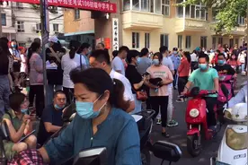 郑州中考第一天，106中学门口家长席地而坐，电动车自行车真多