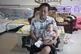 四个月了宝宝在爷爷的大腿上坐着，手舞足蹈。视频封面