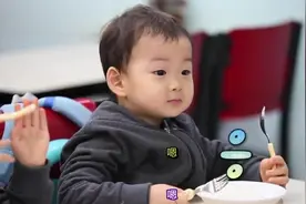 民国一口吃掉大块炸鸡，爸爸打扰民国吃东西，民国用眼神表达不满