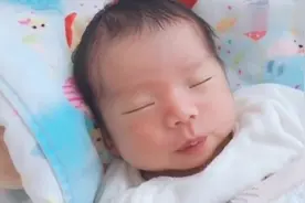 半睡半醒中的小宝宝真可爱，一会笑一会皱眉头，这是做美梦了吧