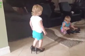 小宝宝偏要穿妈妈的高跟鞋，结果穿上后不会走路了，妈妈看乐了！
