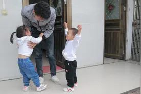 俩小孩特别喜欢爸爸，要爸爸同时抱俩个，爸爸是怎样做的呢？