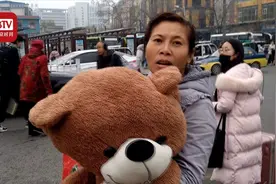 最暖站票族！打工女子坐16小时无座车为女儿带1.5米高熊娃娃