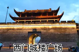 傍晚西门城楼广场纳凉的市民们跳广场舞，打太极拳，骑自行车