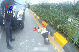 主干道车流穿梭，男子躺倒路中央车辆纷纷避让，民警现场紧急处理