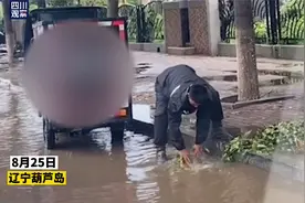 辽宁葫芦岛暴风雨后一快递小哥徒手清理排水口