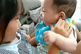 宝宝的小胖脸被姐姐挤弄，气得宝宝要咬人，画面太搞笑了！视频封面