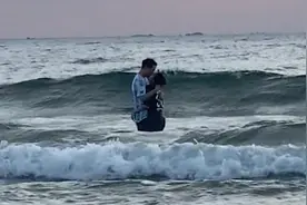 情侣看日出站海浪里拥吻险被冲倒 目击者：全程十几分钟 很危险视频封面