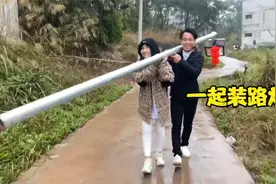 韦庆达和乡亲们一起装路灯，以后再也不怕走夜路了，连夜赶工装好