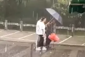 广西一老人暴雨中淋雨前行，一对情侣帮打伞陪走20分钟被淋透