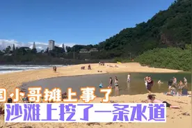 外国小哥在沙滩挖一条水道，结果变成几十米的河流