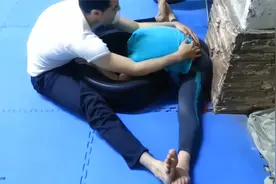男孩们排队让教练进行柔韧性压腿训练视频封面
