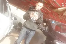 地上洒了一地的汽油，男子却仍自顾自的抽烟，存在严重安全隐患