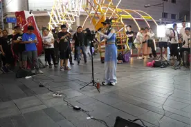 美女戴个墨镜在街头唱歌，怕别人认出她，有点不好意思