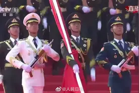 此刻，礼炮响起，三军仪仗队护卫国旗铿锵前进