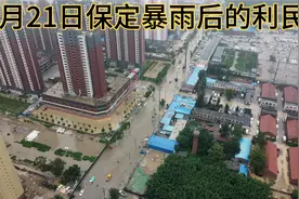 这就是雨后保定的马路，积水达百米长，汽车和行人排队等待通过。