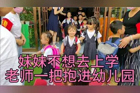 姐妹一起去上学，妹妹反悔不想去，被老师一把抱进幼儿园视频封面
