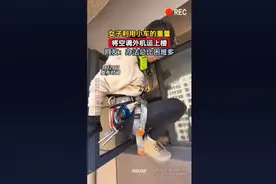 女子利用小车的重量，将空调外机运上楼，网友：办法总比困难多。