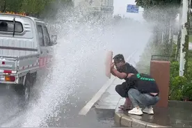 #下雨天可以这样玩 #求溅水  雨中快乐的社牛小伙，路边积水处举牌“求溅水”视频封面