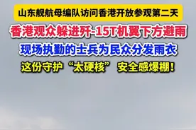 山东舰航母编队访问香港开放参观第二天，香港观众躲进歼-15T机翼下方避雨，现场执勤的士兵为民众分发雨衣，这份守护“太硬核”，安全感爆棚！
