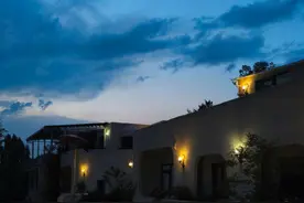 倘若你感觉活腻了，不妨去民宿打工吧。 生活里攒够了焦虑，如同口袋中塞满了无用的硬币，便拖着行李箱，一头栽进这山间民宿里。 别人都说“这儿清净，风景好”可是这里的风景跟我有啥关系呢？ 当我弯腰俯身，手臂机械地来回划动，汗水顺着眉梢流下，滴落在地面上，又被迅速抹去，日头当顶，灼热烤着地面，我弯腰在院中收拾客人留下的狼藉，皮肤晒得生疼，汗水浸透衣裳，这都是我的日常.....这里客来客往，把我熬成了脸盲，客人兴致勃勃的欣赏着这里的美景，脚底沾着山间尘泥，踏过我刚刚清理的地面，留下清晰的足迹，犹如时间无情的刻痕，我唯有擦完一遍，再擦一遍。                                                                                                  夜幕终于降临，拖着疲惫的双腿爬上楼顶，望着天边绚烂的晚霞，又熬过了一天。    下班躺在床上，舍不得入睡，属于我的自由就在这万籁俱寂的黑夜，我竟莫名地感到心安，今天又挣到了自己的窝囊费！  客人更是形形色色，有挑剔贵妇，也有豪爽的大佬，带着一身酒气，夜晚的喧哗，搅扰了乡野的宁静，我们陪着笑脸，召之即来挥之即去，尊严在这里，它被悄悄折叠起来装在口袋。 原来服侍人，竟是这般的心力消磨。 偶尔当终于忙里偷闲，坐在廊下远望，眼前山色渐次展开，云雾缭绕，浓淡相宜，远处仿佛一幅水墨长卷。 此刻，时间似乎真的凝滞了。我竟不由自主地数起了日子：一天、两天……后来却渐渐模糊了数字的意义。   在数着日子的间隙里，我竟窥见了时间本身的模样，像这山间的流云，缓缓地，从我的凝视里从容淌过。 原来所谓“窝囊”，其深处竟埋藏着另一种自由—— 一种无须向虚妄意义低头的自由，一种用双手劳作换得坦荡喘息的自由。 人若活腻了，不妨真去民宿试试。那些劳役般的筋骨之累，那些磨平了棱角的笑脸迎人，竟意外地成为生命困顿之际的另类渡劫。   在日复一日俯身擦拭中，一点点洗去心头的尘嚣；在数着山间流云的日子里，终于听见了时间本真之音——它并非鞭策，而是生命从容流淌的韵律。最终你会明白，活着就要不停劳作，沾着尘与汗的日子换来的窝囊费将会是你有朝一日的生活底气！