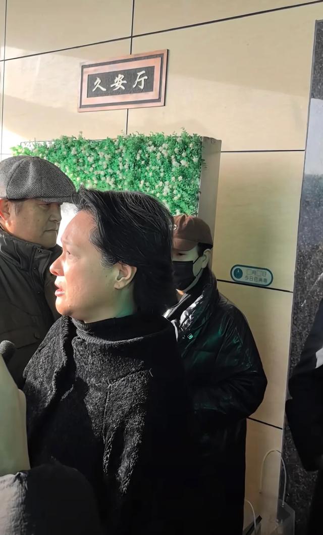 许何弯着腰抱着何晴遗像,背影很难过,许亚军没来给何晴撑伞!