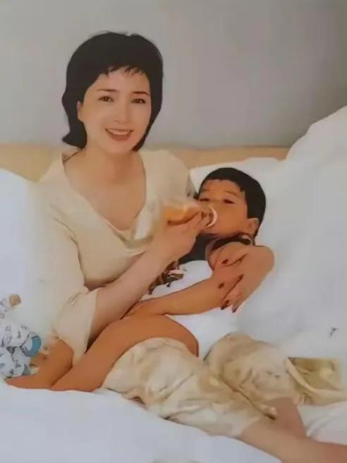 许何弯着腰抱着何晴遗像，背影很难过，许亚军没来给何晴撑伞！