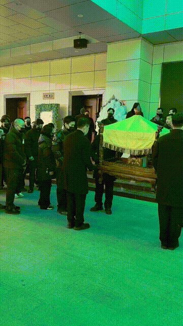 许何弯着腰抱着何晴遗像	，背影很难过，许亚军没来给何晴撑伞！