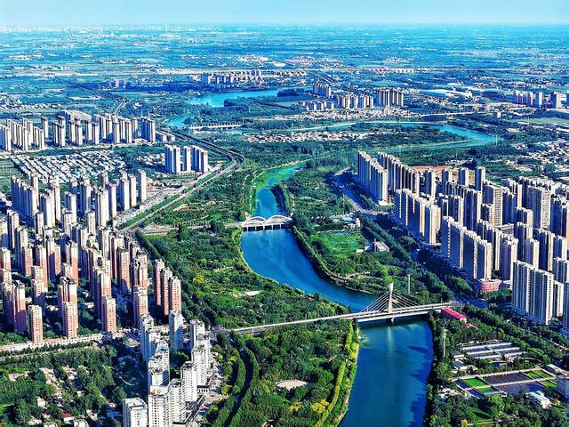 禹州市区的颍河碧波荡漾，两岸绿树成荫，城市美景入画