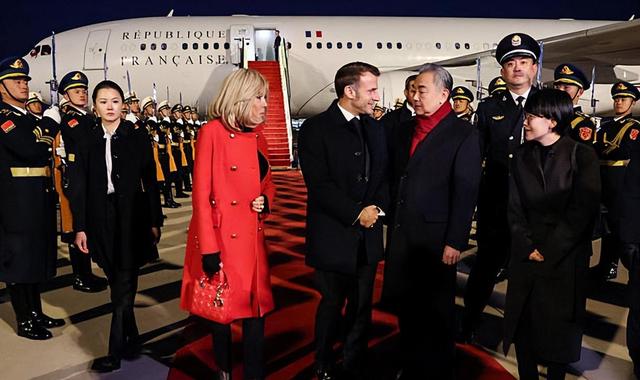 72岁法国第一夫人抵京惊艳，红大衣配戴妃包超美