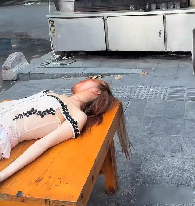 女子晚上喝得酩酊大醉，躺在烧烤摊的桌子上睡着了：天亮了还没醒