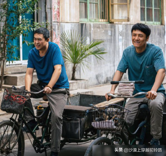 55岁张嘉益在西安骑三轮车，车上坐着秦海璐	，民工的打扮很接地气