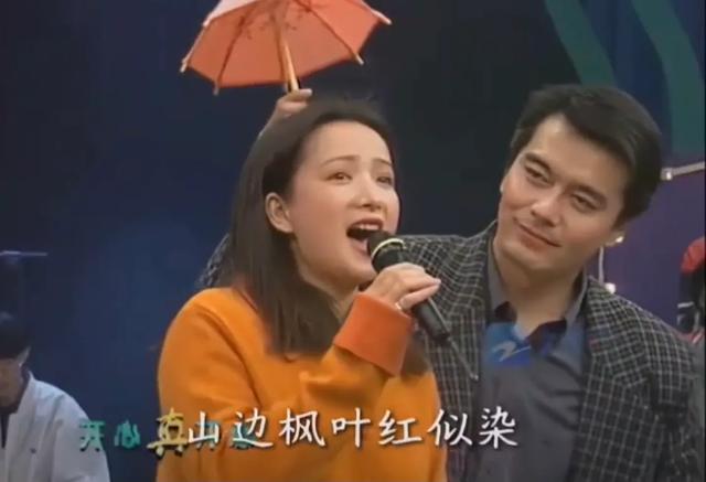 许何弯着腰抱着何晴遗像	，背影很难过，许亚军没来给何晴撑伞！