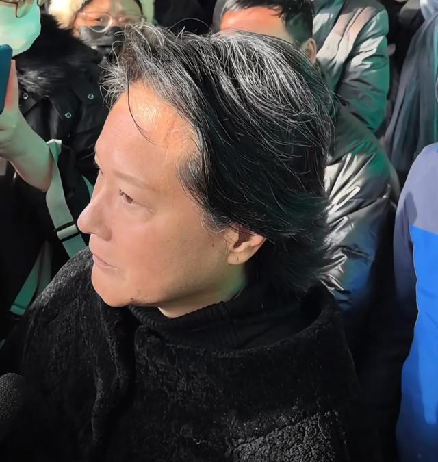 许何弯着腰抱着何晴遗像，背影很难过	，许亚军没来给何晴撑伞！