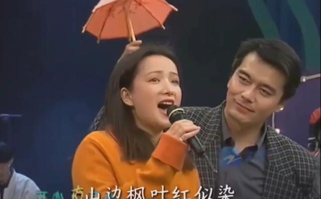 许何弯着腰抱着何晴遗像	，背影很难过，许亚军没来给何晴撑伞！