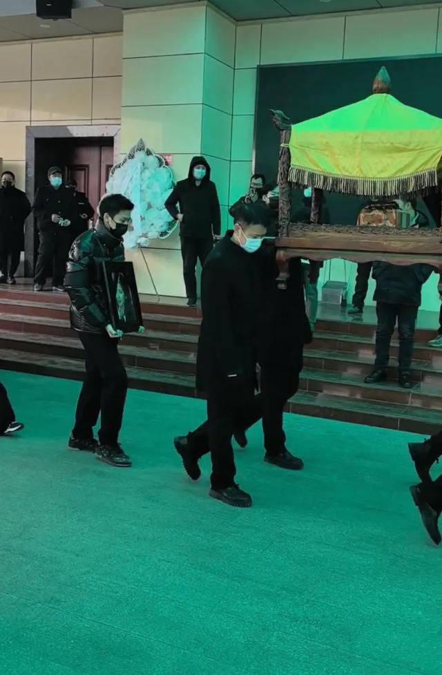 许何弯着腰抱着何晴遗像，背影很难过	，许亚军没来给何晴撑伞！