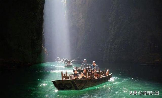 峡谷小溪清澈见底，阳光金束洒水面，小木船如仙境般飘过