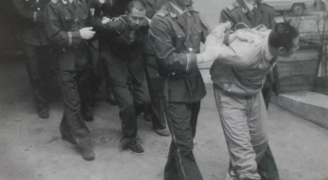 80年代，武警正在捆绑罪犯的场景，这种绑法越挣扎捆绑的越紧