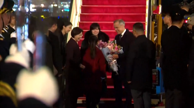 加拿大总理抵达北京，大冷天就穿一件小风衣	，献花小朋友超漂亮