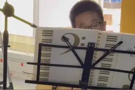 八岁男孩街头弹吉他卖艺，却获众人称赞？妈妈：孩子主动提出，手都弹破皮了图片